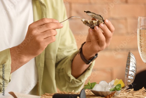 Young man holding raw oyste...