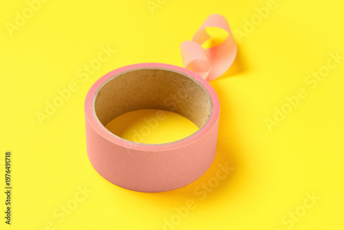 Pink masking tape roll on y...