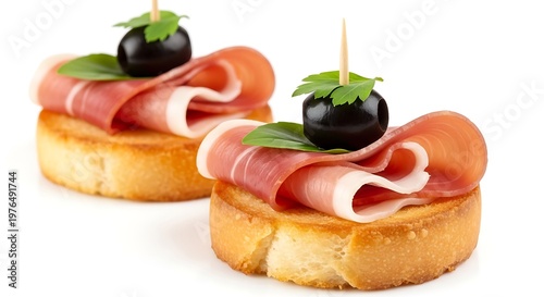 Two gourmet appetizers with prosciutto basil black olives on toasted bread slices finger food white background appetizer prosciutto delicious