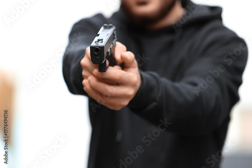 Foto Man with gun aiming outdoors, closeup