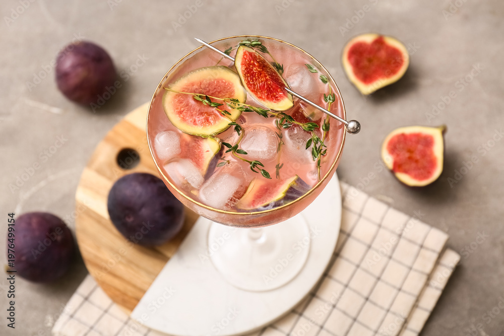 Fototapeta premium Glass of tasty fig lemonade on grey grunge background, closeup