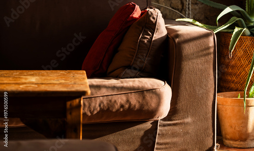 Interior decor in a vintage house, a cozy sofa and wooden table closeup..