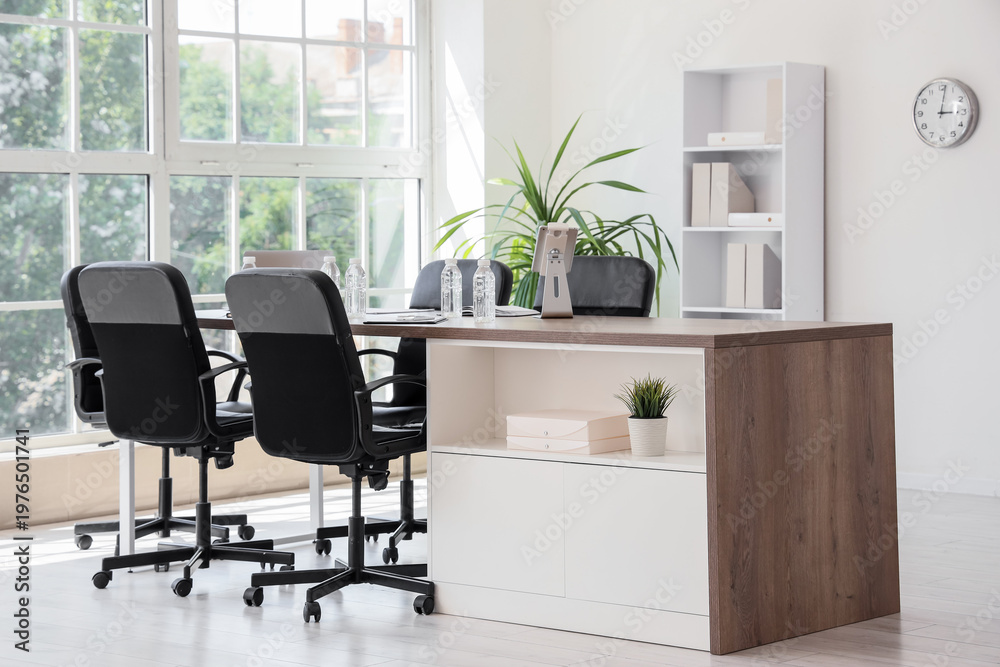 Fototapeta premium Interior of conference hall with desk, shelf unit and palm plant