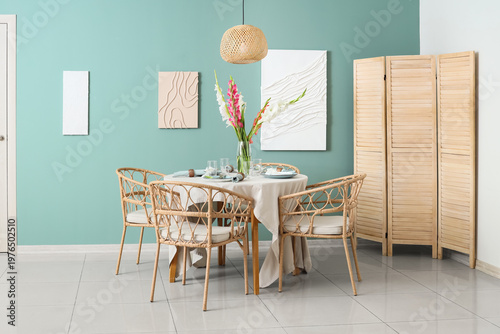 Served dining table with plates and beautiful gladiolus flowers in interior of stylish dining room