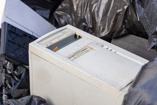 Tableau sur toile An old PC thrown into a trash pile along with black trash bags, photographed in daylight