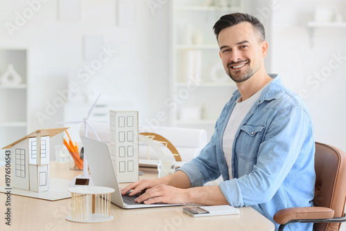 Male architect working with laptop at table in office