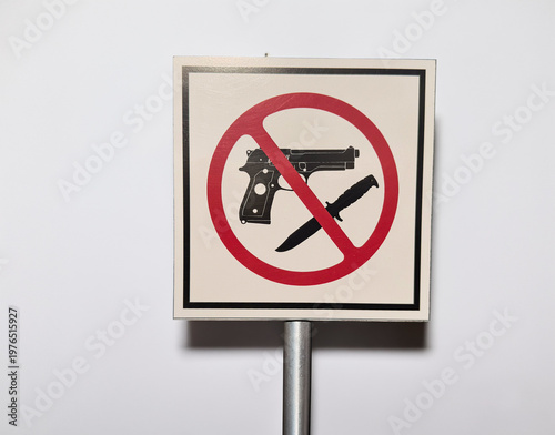 A sign with a graphic prohibiting weapons on a white background