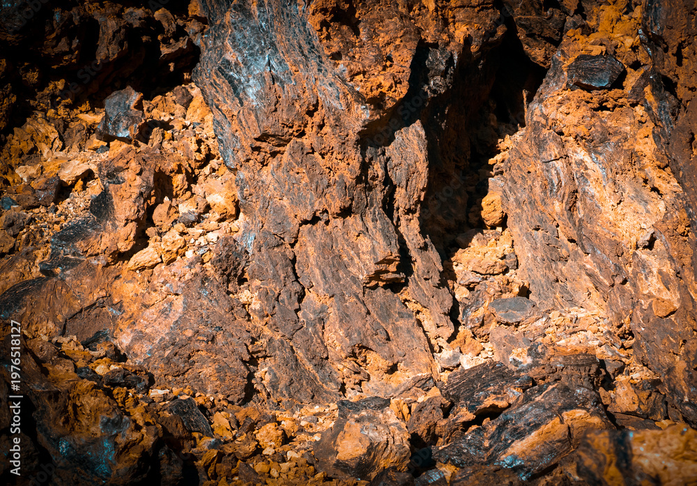 Fototapeta premium Lava formations, stones, black basalt in the rocks closeup on a volcano terrain.