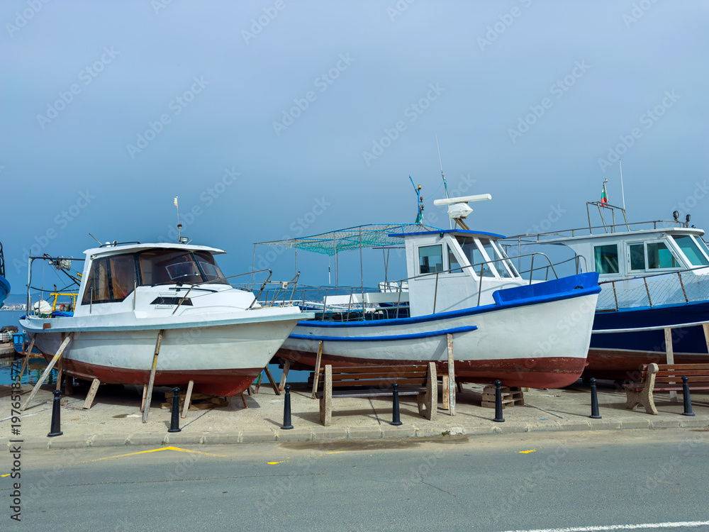 Fototapeta premium Boats docked at the harbor on a cloudy day in a coastal town during late afternoon hours