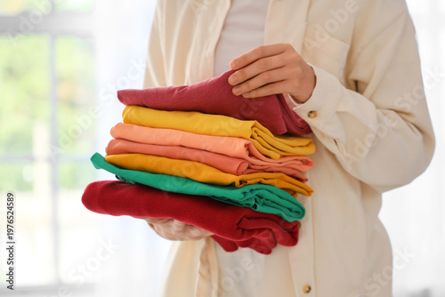 Young woman holding stack o...