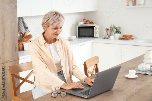Mature woman using laptop a...