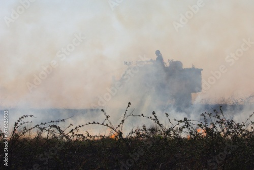 Фотография Rural firefighters are battling a grass/brush fire in heavy smoke