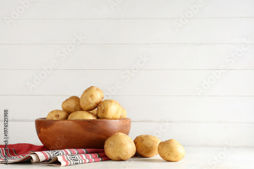 Wooden bowl with raw potato...