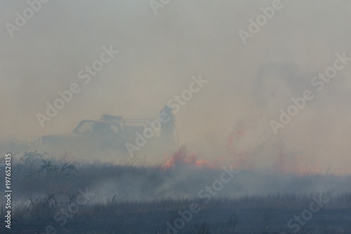 Vászonkép Rural firefighters are battling a grass/brush fire in heavy smoke