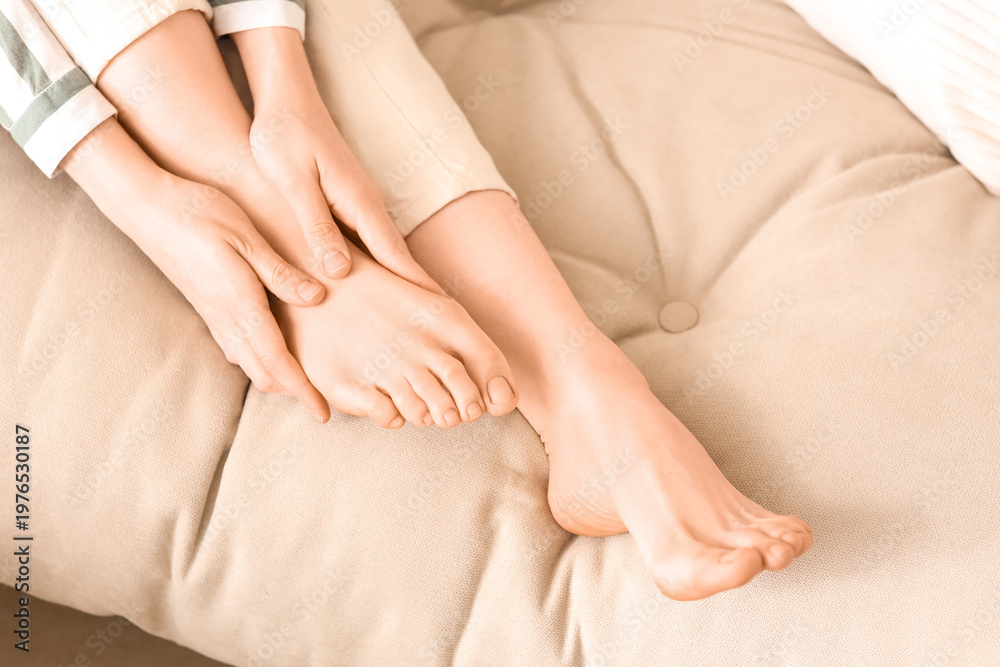 Fototapeta premium Female hands making foot massage on sofa