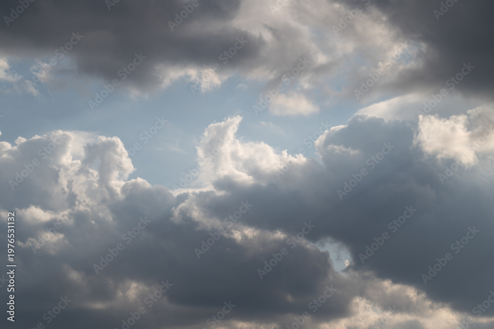 Fototapeta premium Sky with sunlight. Sunshine piercing through cloudy sky. Cloudfilled sky illuminated by scattered sunbeams. Overcast sky with bright rays breaking through heavy clouds