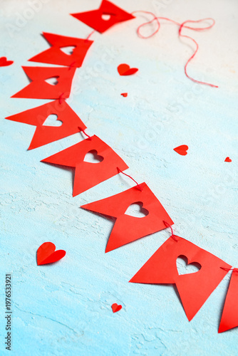 Garland made of red paper flags with hearts on blue background. Valentine's Day celebration