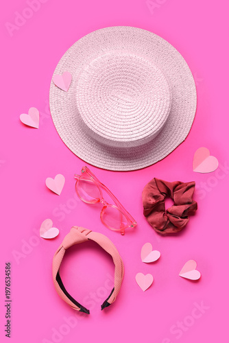 Hat with eyeglasses, hair accessories and hearts on pink background. Valentine's Day celebration