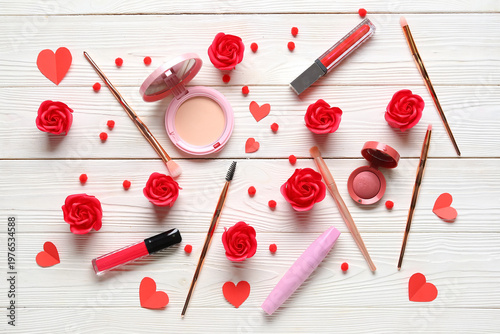 Cosmetic products with decorative roses and hearts on white wooden background. Valentine's Day celebration