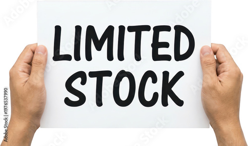 Two hands hold a white paper with the words LIMITED STOCK written in bold black letters conveying scarcity and availability holding sign text message concept information notification