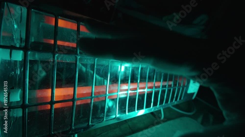 Hand Warming Near Infrared Heater with Cyan and Orange Glow | Electric Space Heater Close-Up in Dark Room | Heat and Light Contrast at Night