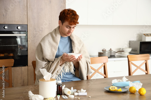 Ill young man eating soup i...