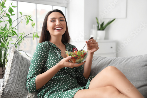 Young woman eating vegetabl...
