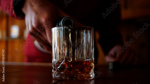 Male Bartender Pours a Glass of Whiskey in Trendy Bar
