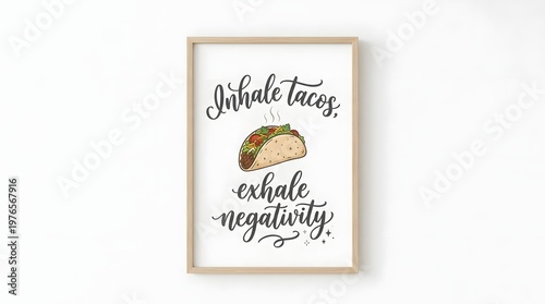 A framed motivational print featuring hand-lettered text 'Inhale tacos, exhale negativity' with a colorful illustration of a taco in the center, against a white wall.