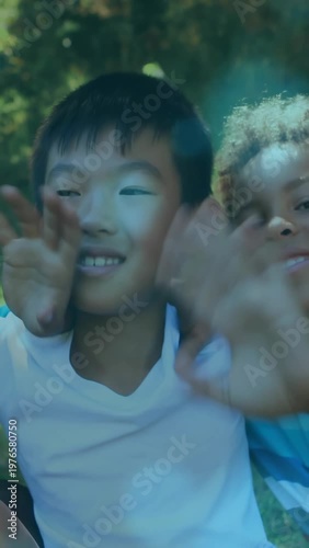 Vertical video: Cam pulling, two boys leaning into lens, reaching, creating social ad with sunspots