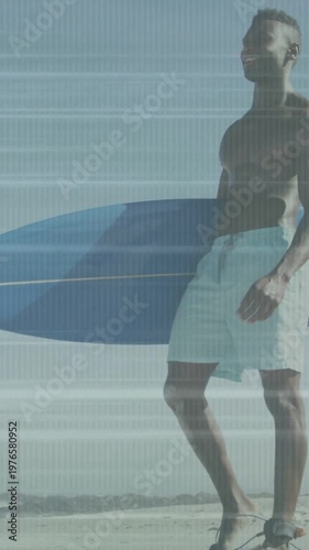 Vertical video: Spotting waves, surfer walking beach holding blue surfboard preparing to surf