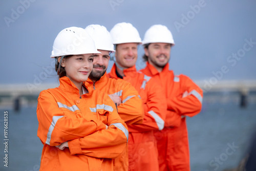 Engineering team members standing with arms crossed at a shipyard