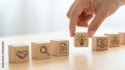 This concept image displays wooden blocks with icons, symbolizing the solution-focused Design Thinking Process and its stages.