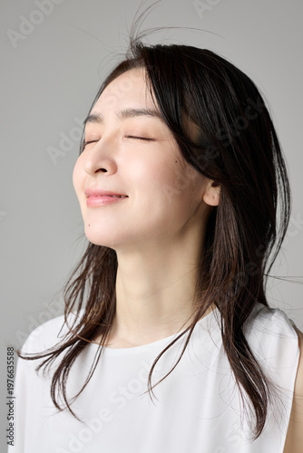 目を閉じて微笑む40代女性のポートレート