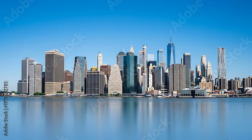 Panoramic View of a Modern City Skyline Reflected in Calm Water Under a Clear Blue Sky