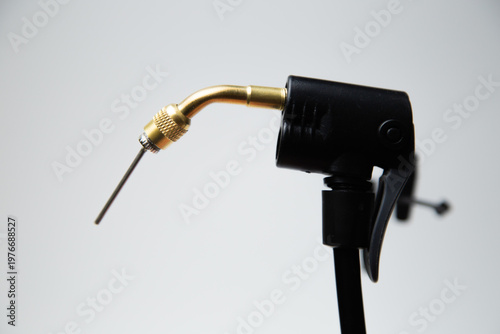 Close-up needle for inflating tires of a part of a black pump on a white background. High quality photo