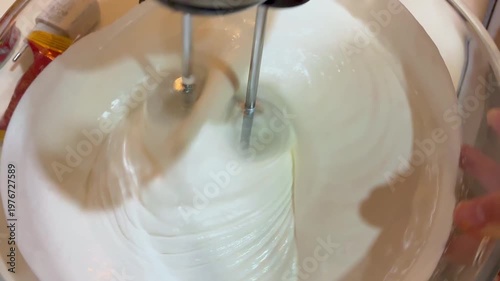 The process of whipping icing from egg whites and sugar using a mixer
