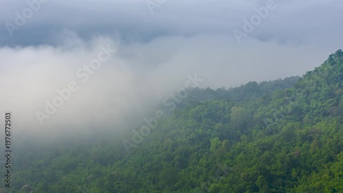 4K video of an aerial view of beautiful clouds or fog moving over the mountain peaks in northern Thailand.