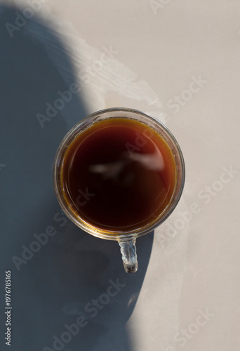 A cup of tea with light and shadow on the table.
