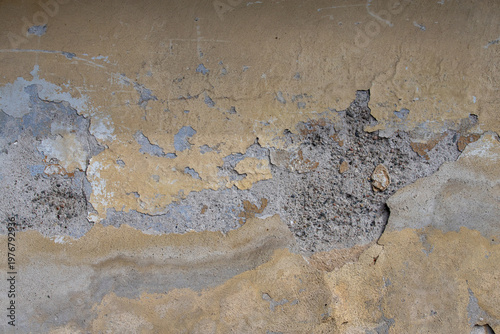 Weathered peeling plaster wall with cracked paint and rough concrete texture ...