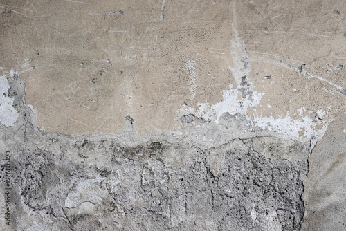 Weathered concrete and peeling plaster form a cracked, rough wall surface wit...