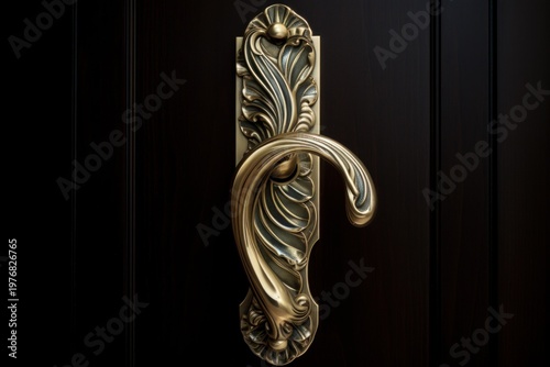 Ornate brass door handle adorning a luxurious dark wooden door, showing antique craftsmanship