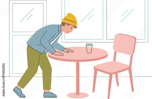 Man in yellow hat cleans pink table with cloth near chair indoors