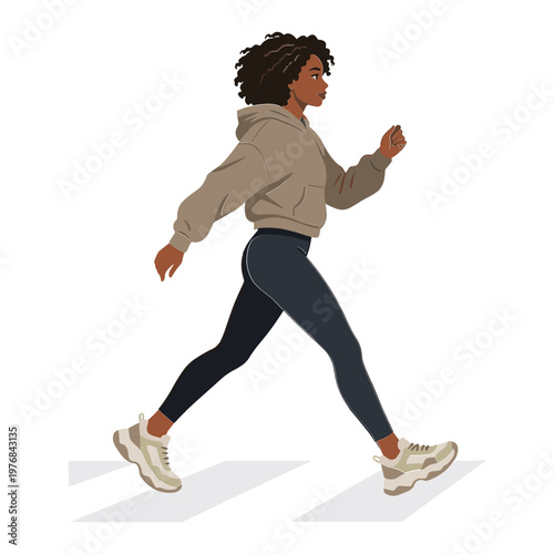 A woman wearing a hoodie runs quickly on a city street.