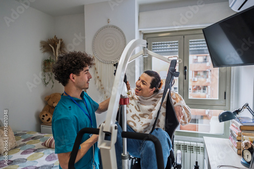 Photos Caregiver assisting woman using mobility lift at home