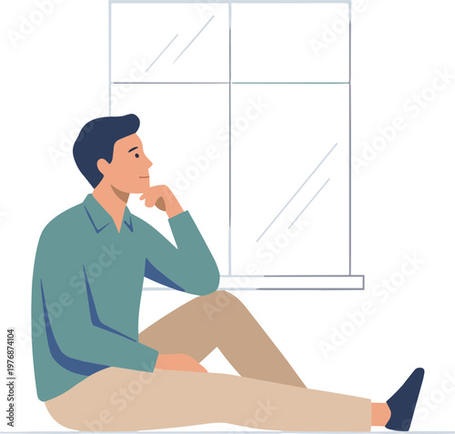 A man sits on the floor near a window looking thoughtful