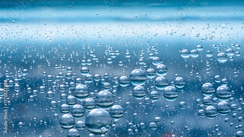 Fotografie Oil and water droplets mixing in blue abstract liquid