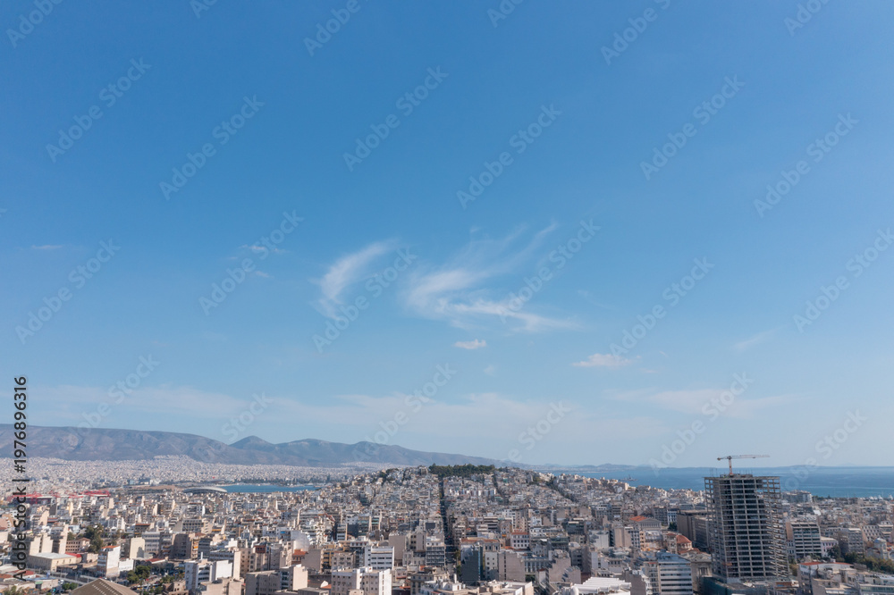 Fototapeta premium Wide panoramic view of Athens city with buildings, mountains and clear blue sky in Greece