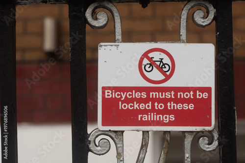 No bicycle parking sign on metal railings in urban area