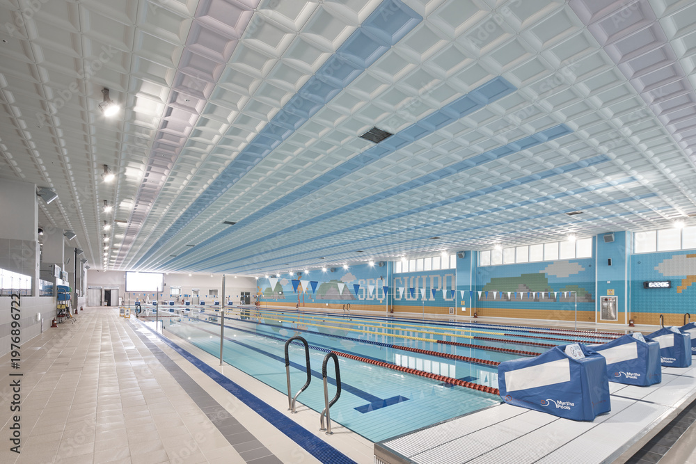 Fototapeta premium Large indoor pool with blue lane water and modern acoustic ceiling